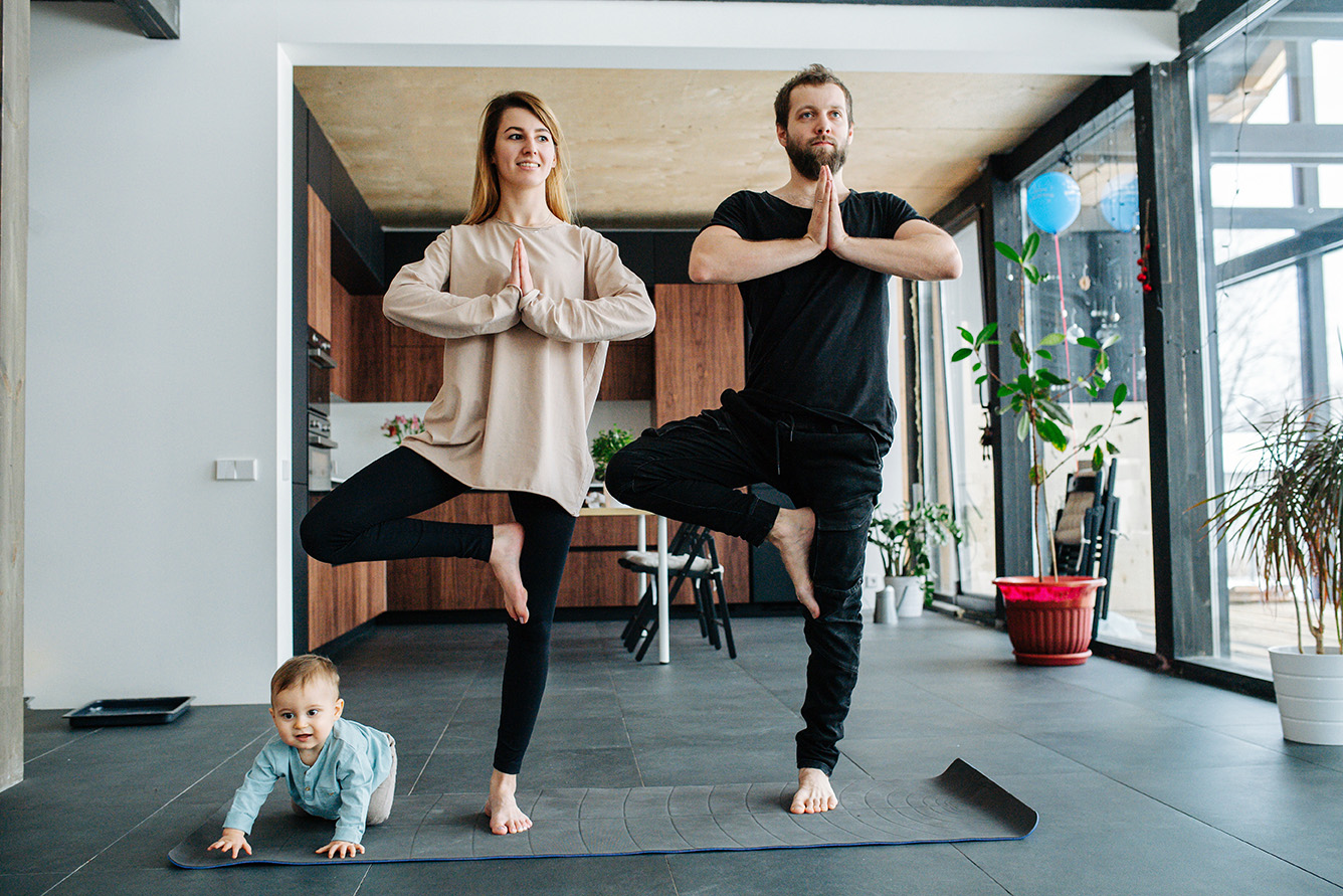 Mother and father doing yoga while spending time with their child